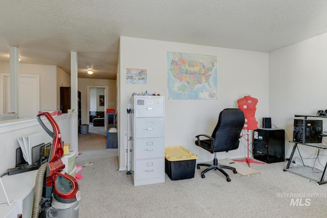 carpeted office with a textured ceiling