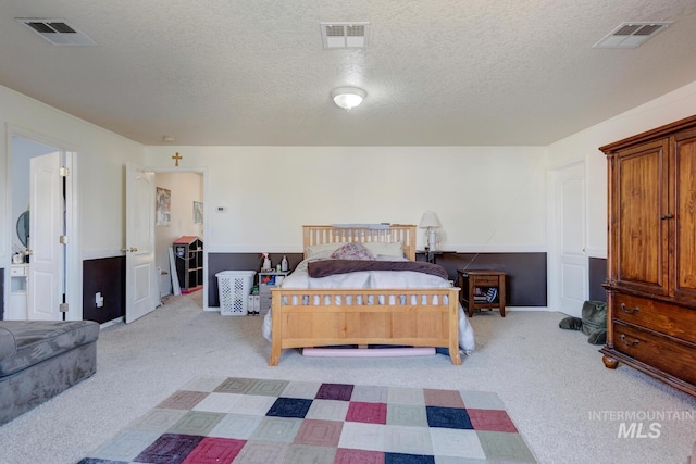 bedroom with light carpet and a textured ceiling