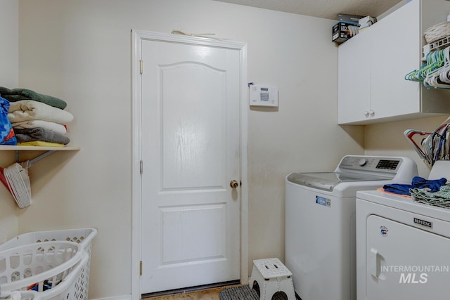 laundry area featuring cabinets, a textured ceiling, and washer and clothes dryer