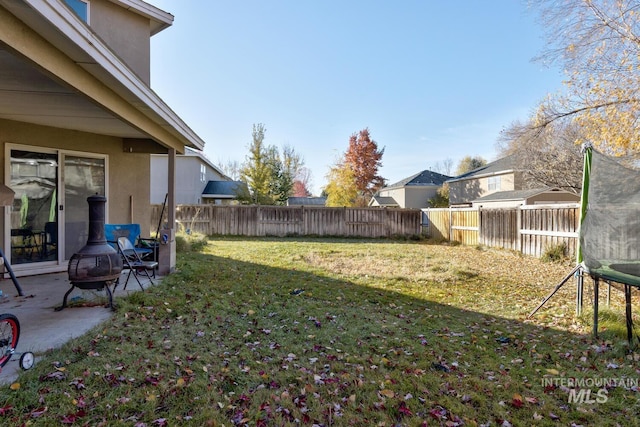 view of yard with a fire pit and a trampoline