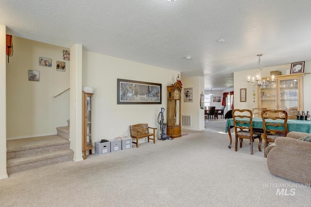 carpeted living room with a textured ceiling and an inviting chandelier