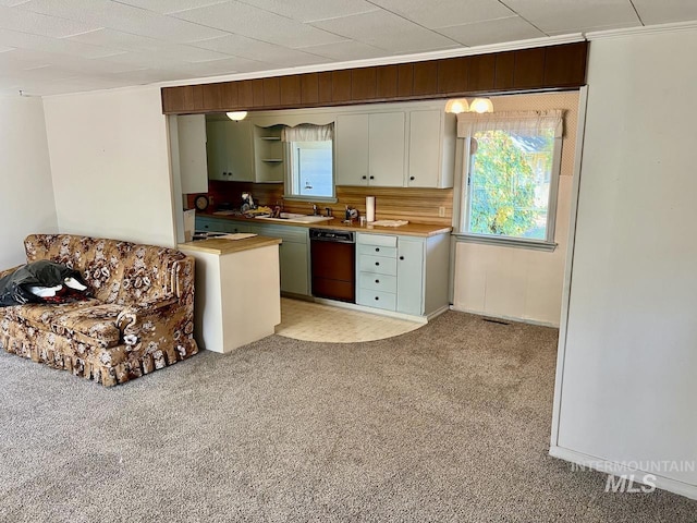 kitchen featuring white cabinetry, crown molding, black dishwasher, and light carpet