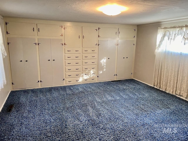 unfurnished bedroom with a textured ceiling and carpet floors