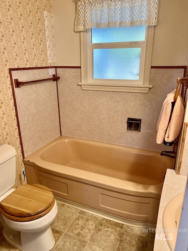 bathroom with toilet and a washtub