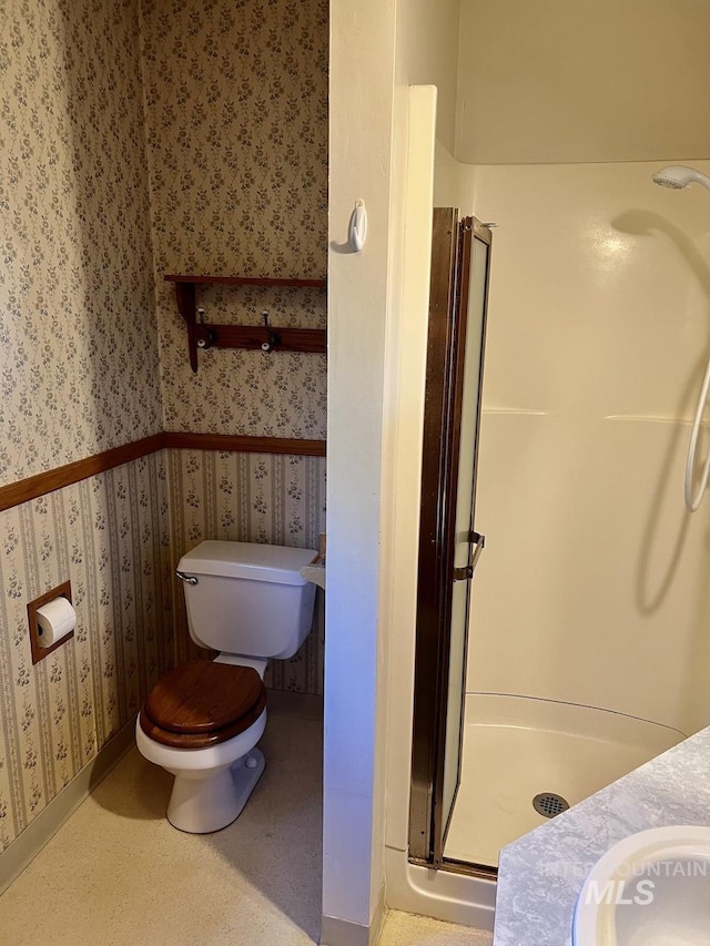 bathroom with toilet, a shower with shower door, and vanity