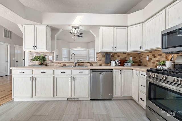 kitchen featuring light countertops, visible vents, appliances with stainless steel finishes, white cabinetry, and a sink