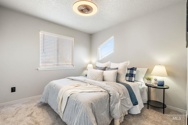 carpeted bedroom with a textured ceiling and baseboards