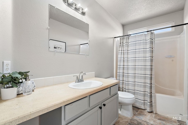 bathroom with shower / bathtub combination with curtain, toilet, stone finish floor, a textured ceiling, and vanity