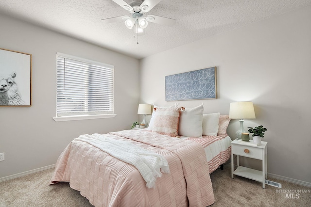 bedroom featuring a ceiling fan, a textured ceiling, baseboards, and carpet flooring