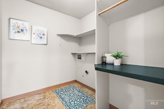 laundry room with a textured ceiling, laundry area, washer hookup, and baseboards