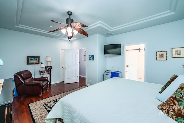 bedroom with ceiling fan, visible vents, a raised ceiling, and wood finished floors