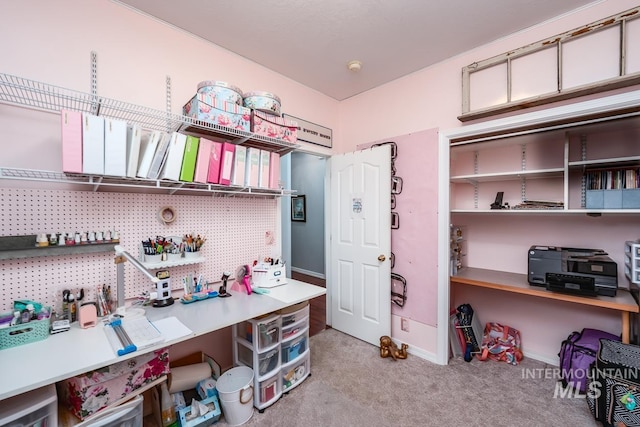 carpeted office featuring a workshop area and baseboards