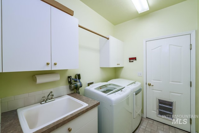 washroom with a sink, cabinet space, and washing machine and clothes dryer