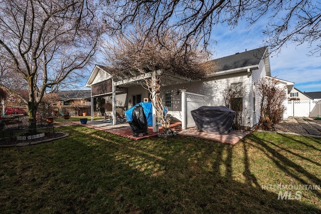 rear view of house featuring a patio area, a gate, a yard, and fence