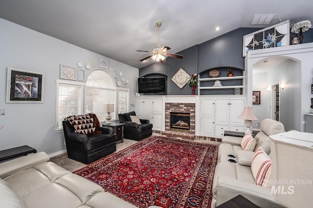 living area featuring a ceiling fan, built in features, carpet floors, a fireplace, and vaulted ceiling