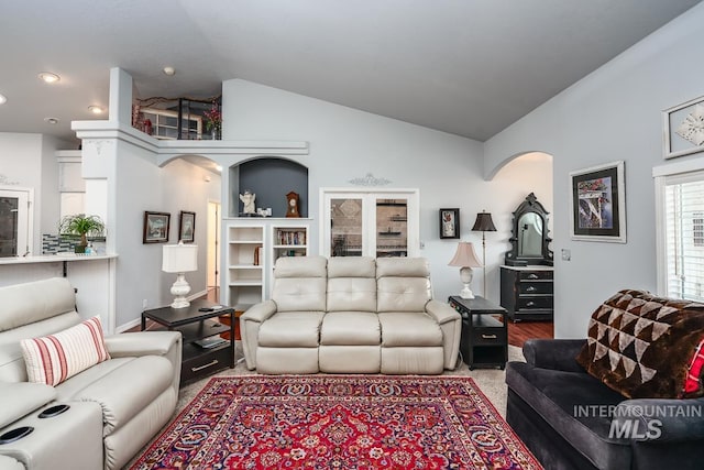 living area with arched walkways and lofted ceiling