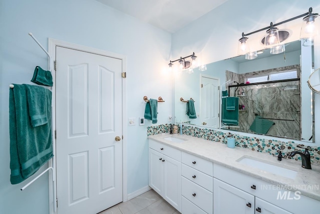 bathroom featuring a sink, a marble finish shower, and double vanity