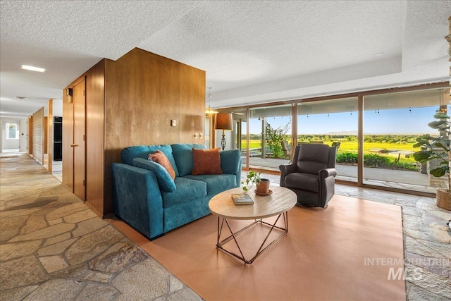 2401 Terrace Dr, Caldwell, ID 83605 - living area with stone floors, a textured ceiling, and wooden walls