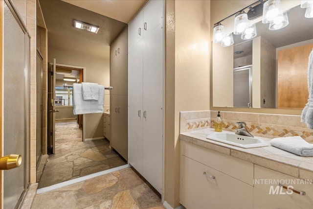 2401 Terrace Dr, Caldwell, ID 83605 - bathroom featuring stone tile flooring, vanity, and a stall shower