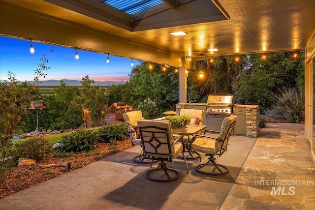 2401 Terrace Dr, Caldwell, ID 83605 - patio terrace at dusk with exterior kitchen, a patio area, and outdoor dining space