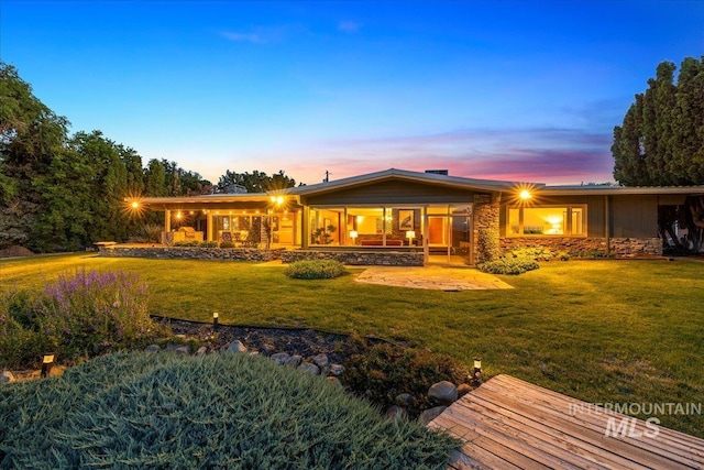 2401 Terrace Dr, Caldwell, ID 83605 - back of house at dusk with stone siding and a yard