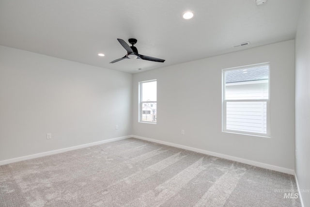 spare room with a ceiling fan, visible vents, baseboards, light colored carpet, and recessed lighting