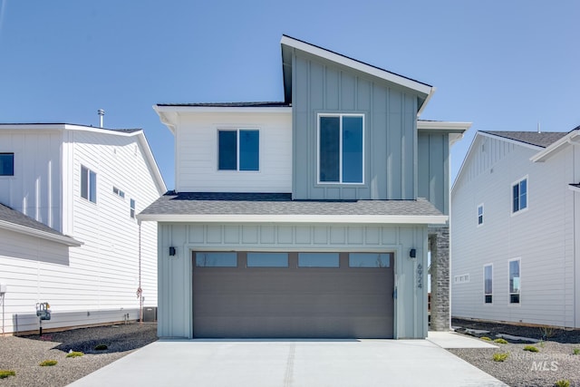 contemporary house featuring board and batten siding, concrete driveway, a shingled roof, and a garage