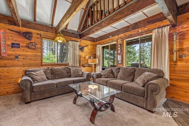 living area featuring a wealth of natural light, beamed ceiling, and wooden walls