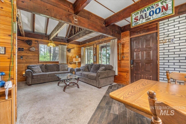 living room featuring beamed ceiling, wood finished floors, and wood walls