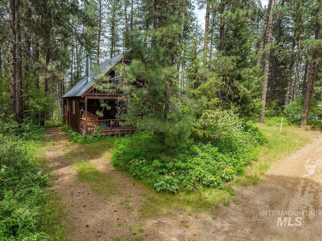 view of yard with a wooden deck and a view of trees