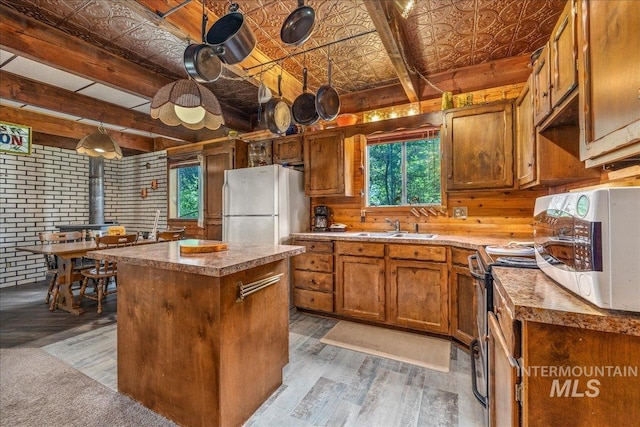 kitchen featuring a sink, an ornate ceiling, light wood-type flooring, plenty of natural light, and white appliances