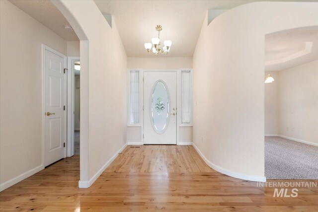 3314 S Raintree, Nampa, ID 83669 - entrance foyer with arched walkways, a chandelier, and light wood-type flooring