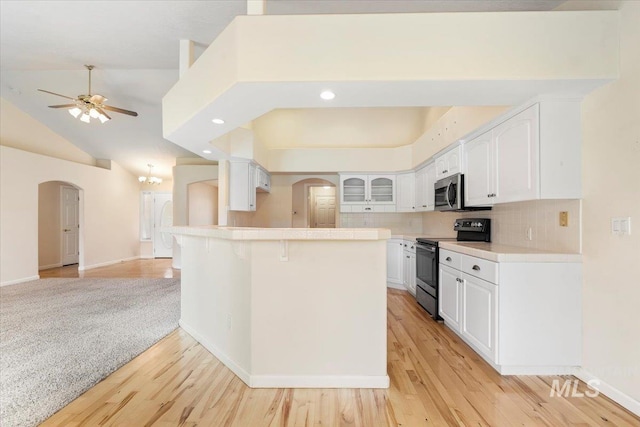 3314 S Raintree, Nampa, ID 83669 - kitchen with stainless steel appliances, arched walkways, light wood-style floors, white cabinets, and a ceiling fan