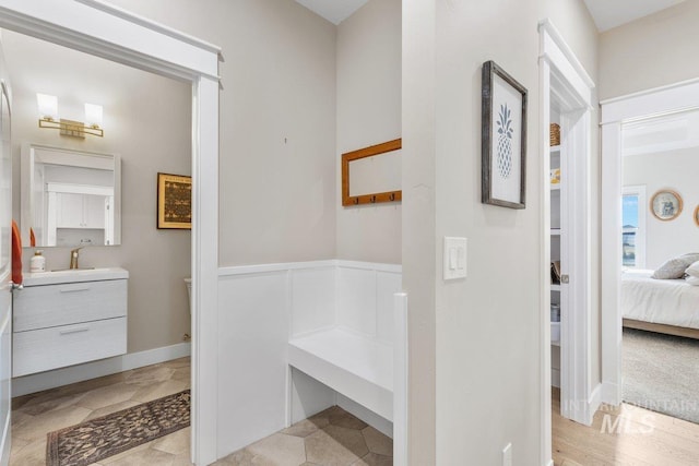 ensuite bathroom featuring a wainscoted wall, vanity, and ensuite bathroom