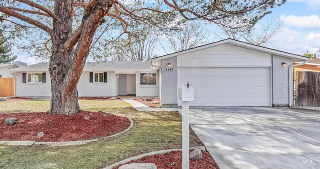 single story home with brick siding, an attached garage, driveway, and fence