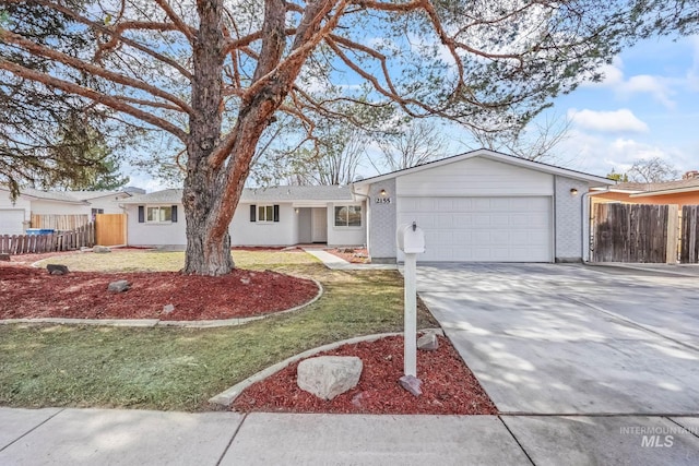 single story home with a front yard, concrete driveway, a garage, and fence