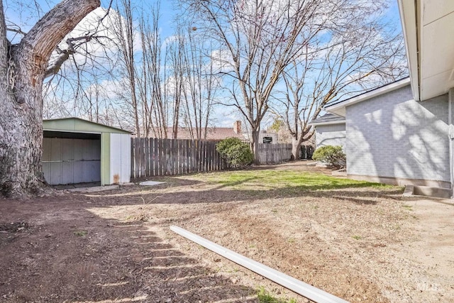 view of yard featuring a detached garage, a storage shed, an outdoor structure, and fence