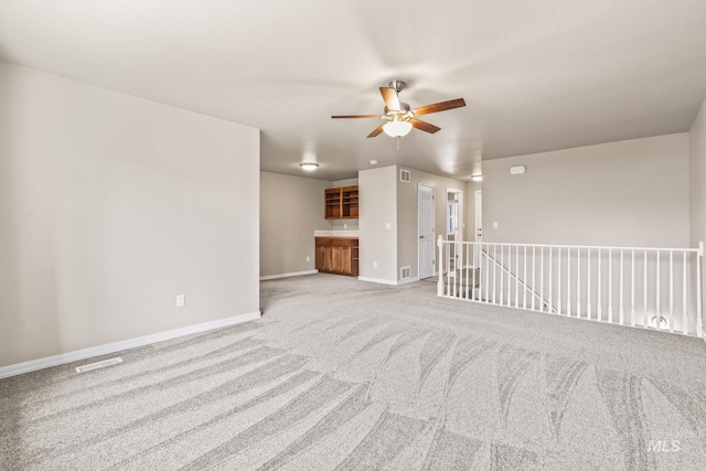 spare room featuring carpet, baseboards, visible vents, and ceiling fan