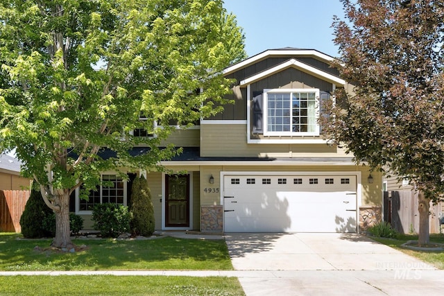 4935 N Rathbone Ave, Meridian, ID 83646 - view of front of home with an attached garage, driveway, board and batten siding, and stone siding