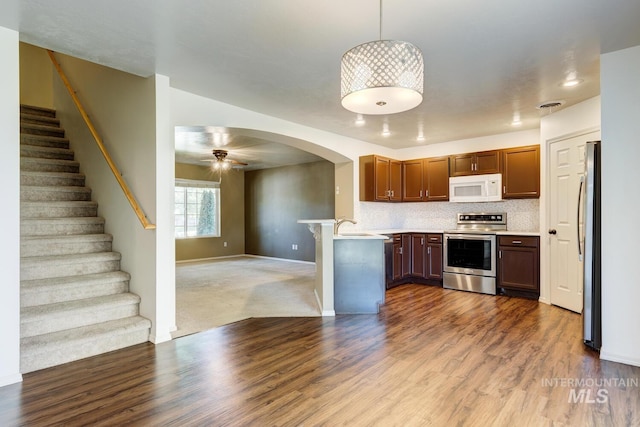 4935 N Rathbone Ave, Meridian, ID 83646 - kitchen with appliances with stainless steel finishes, open floor plan, wood finished floors, light countertops, and ceiling fan