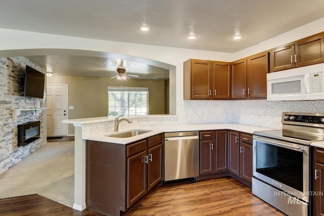4935 N Rathbone Ave, Meridian, ID 83646 - kitchen featuring appliances with stainless steel finishes, light countertops, a peninsula, ceiling fan, and light wood-type flooring