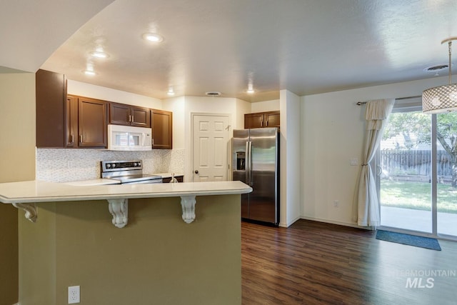 4935 N Rathbone Ave, Meridian, ID 83646 - kitchen featuring appliances with stainless steel finishes, a peninsula, light countertops, a breakfast bar area, and recessed lighting