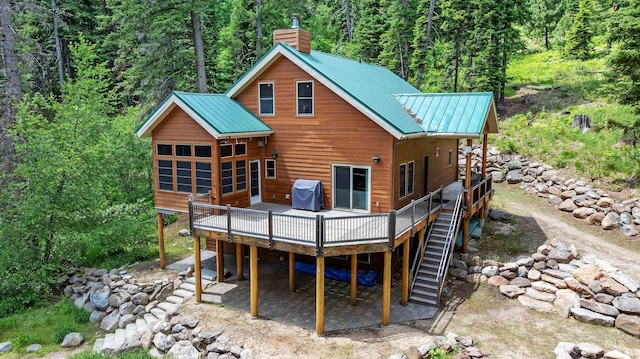 1649 Bear Trl, Donnelly, ID 83615 - back of property with a forest view, a deck, a chimney, stairs, and a metal roof