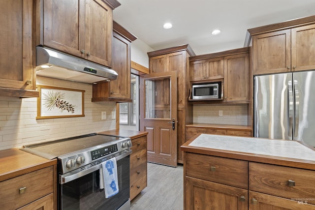1649 Bear Trl, Donnelly, ID 83615 - kitchen with appliances with stainless steel finishes, under cabinet range hood, backsplash, light countertops, and light wood-style floors