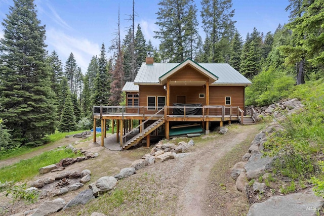 1649 Bear Trl, Donnelly, ID 83615 - chalet / cabin featuring a deck, stairway, a metal roof, a forest view, and a chimney