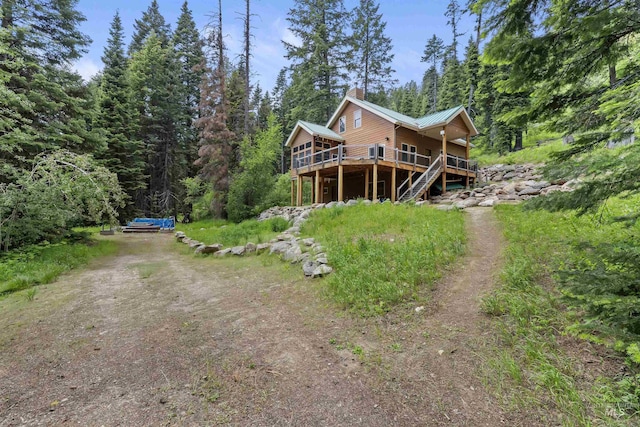 1649 Bear Trl, Donnelly, ID 83615 - back of property with driveway, a wooden deck, a wooded view, stairs, and a metal roof