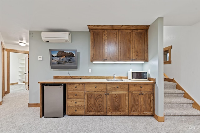 1649 Bear Trl, Donnelly, ID 83615 - kitchen with a wall mounted AC, stainless steel fridge, brown cabinetry, and light carpet