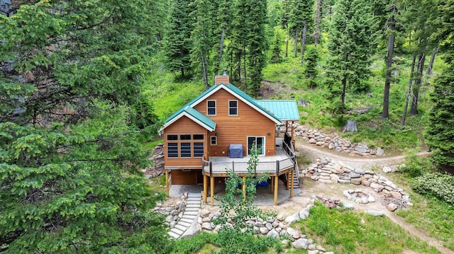 1649 Bear Trl, Donnelly, ID 83615 - rear view of house featuring a wooden deck, stairway, a chimney, a view of trees, and a metal roof