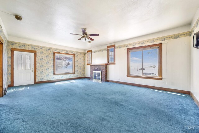 unfurnished living room with a fireplace, carpet, and ceiling fan