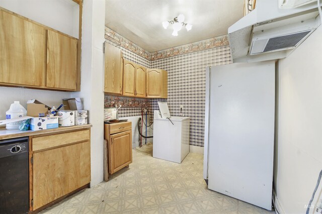 kitchen with white refrigerator, black dishwasher, and washer / dryer
